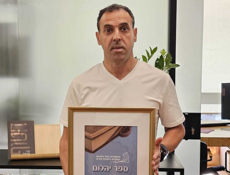 אלי שרעבי מקבל תעודת יהלום על סיפרו.