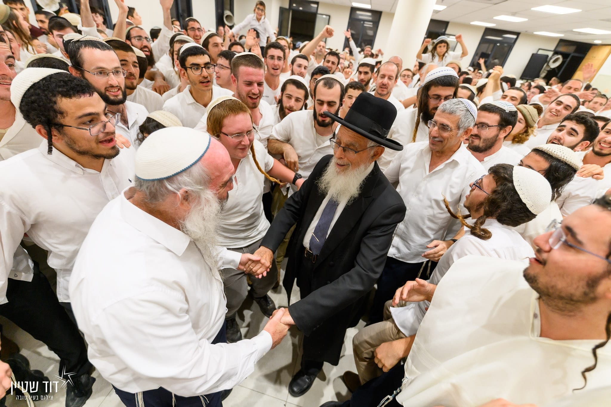 הרב יעקב אריאל רוקד עם הרב יהושע שפירא בישיבה.