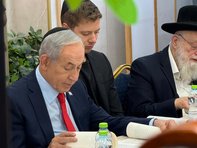 ראש הממשלה בנימין נתניהו עם בנו יאיר בקריאת מגילה בישיבת מרכז הרב