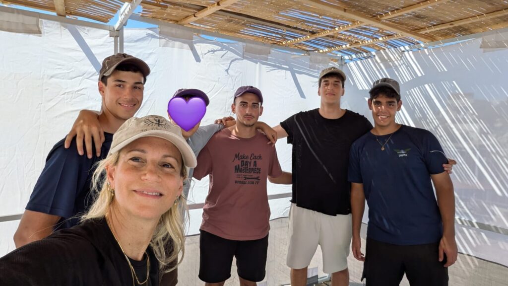 אריאלה, אמו של סרן רואי מילר הי"ד, עם התלמידים שעזרו לה בבניית הסוכה 
