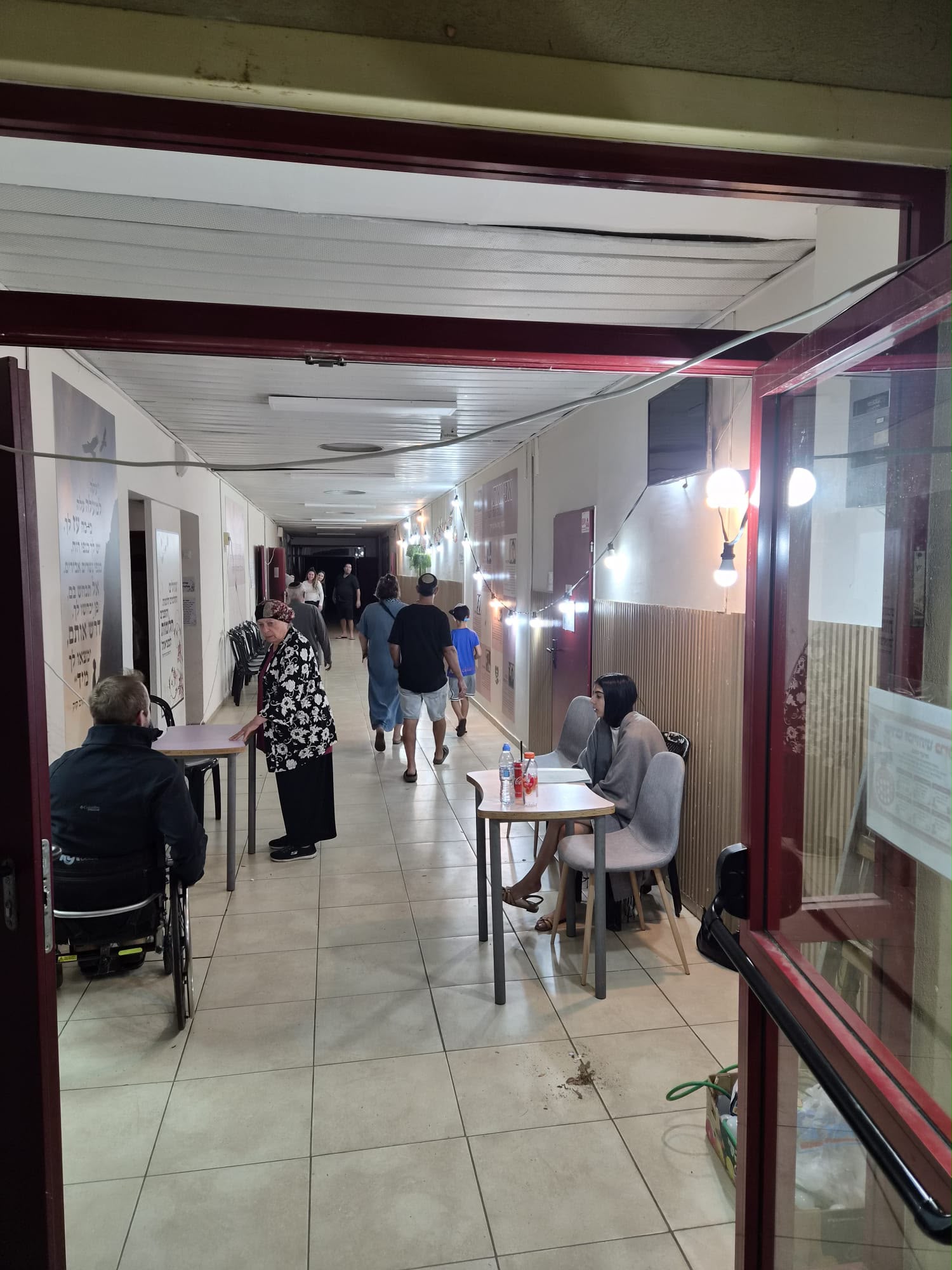 תושבים ממתינים במסדרון המואר בתאורה חלופית