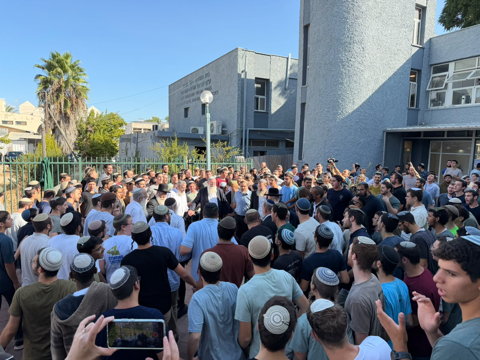 תלמידי ישיבה שרים סביב רבנים בחצר