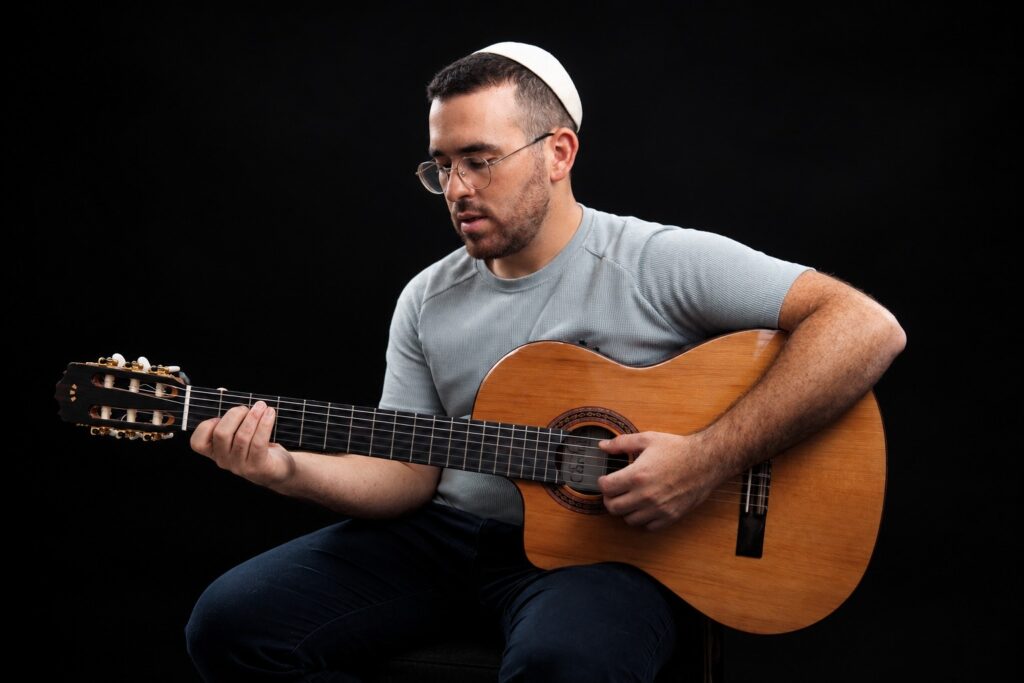 הזמר אליהו רפאל כאין מנגן בגיטרה