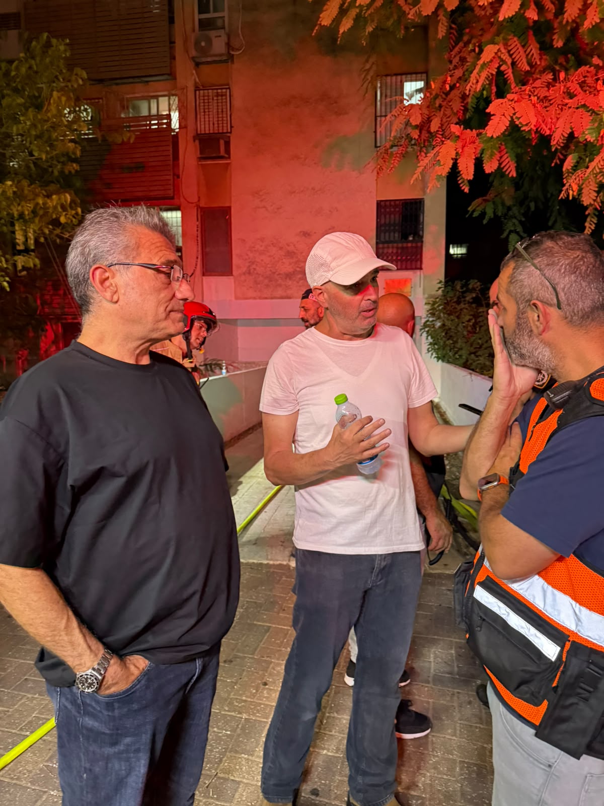 ראש העירייה משוחח עם תושבים ליד בניין השריפה