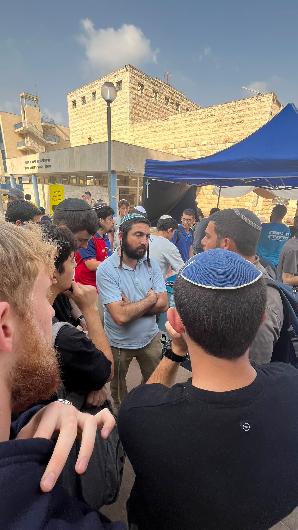 סטודנטים מתעניינים בדוכן מפלגה ביריד