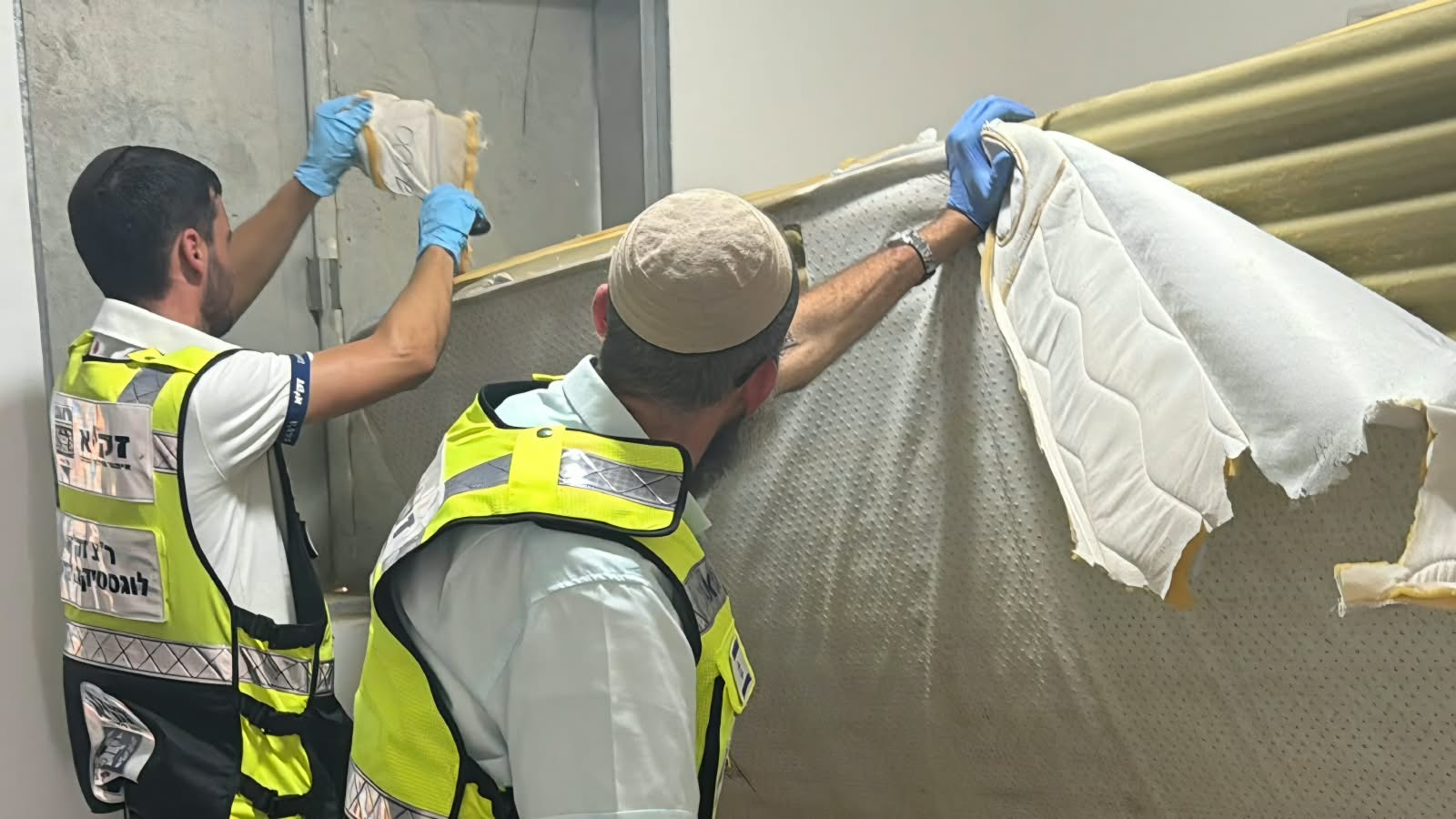 מתנדבי זק"א מסירים מזרן פגוע מהחדר כחלק מהשלמת האיסוף